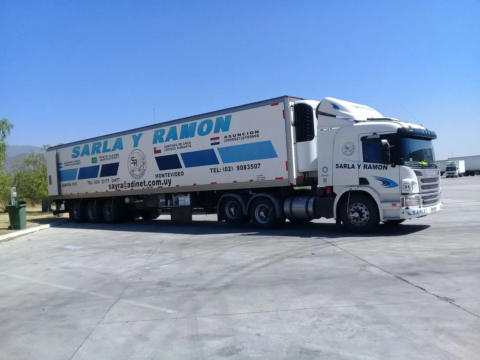 Tractor Scania de Sarla y Ramón con semirremolque refrigerado, con los destinos internacionales rotulados en el furgón