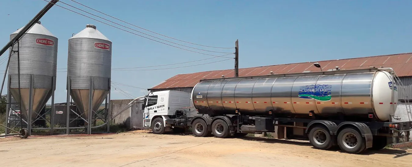Camión cisterna de Sarla y Ramón cargando leche a granel en un tambo, junto a los silos